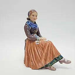 Фигурка сидящей молодой женщины в национальном костюме